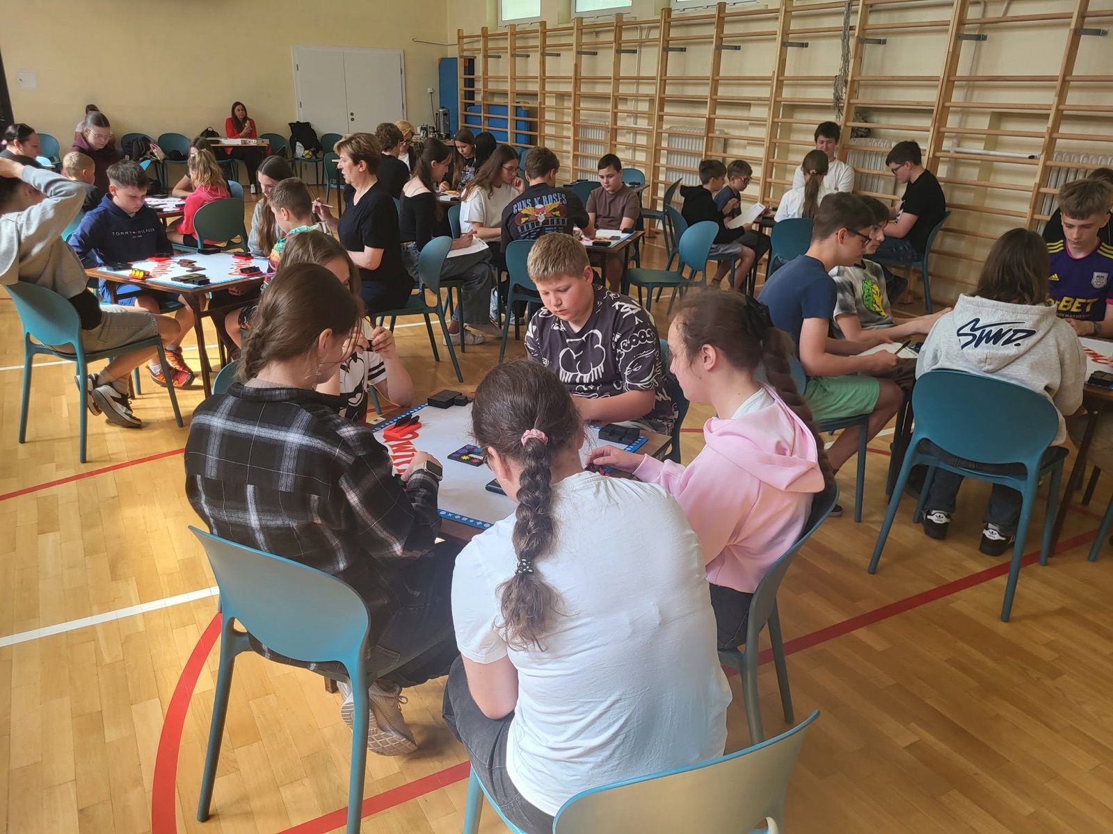 Uczniowie rozgrywający partie Qwirkle podczas Pomorskich Mistrzostw Szkół